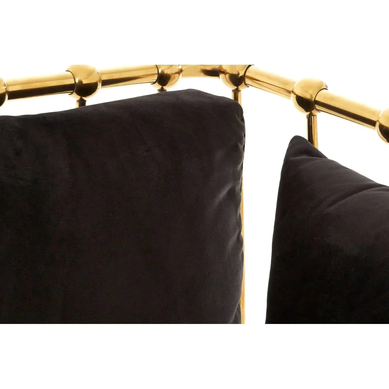 Closeup of black velvet sofa cushions with gold metal frame detail