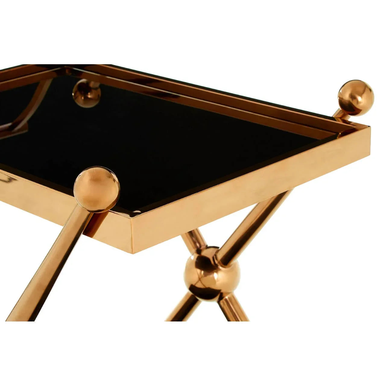 Gold metal side table with black glass top and decorative ball accents, close-up view