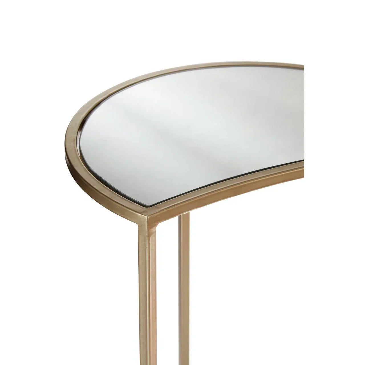 Gold metal console table with mirrored top, close-up of curved edge and frame