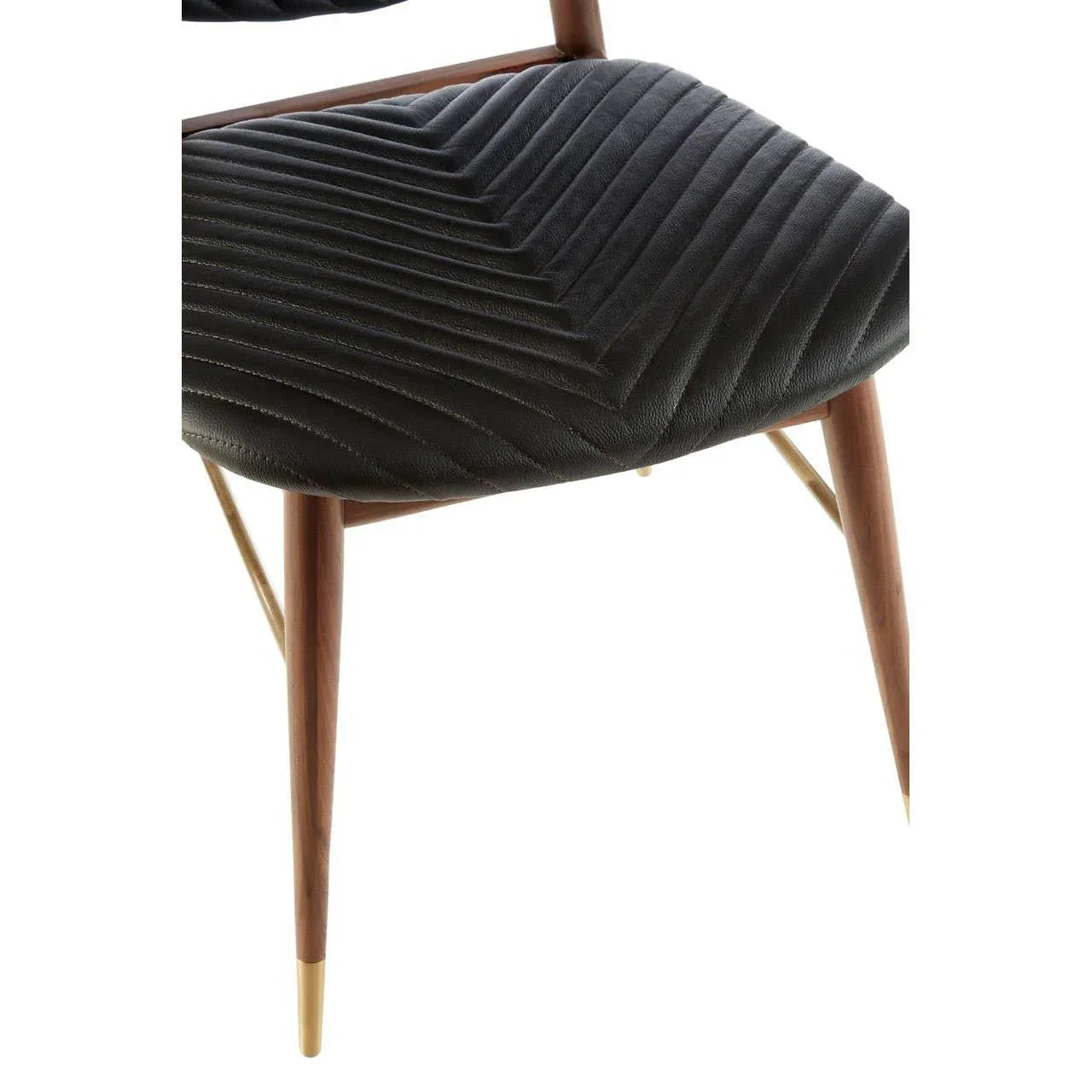 Closeup of dining chair with black chevron stitched seat and wooden legs with gold tips