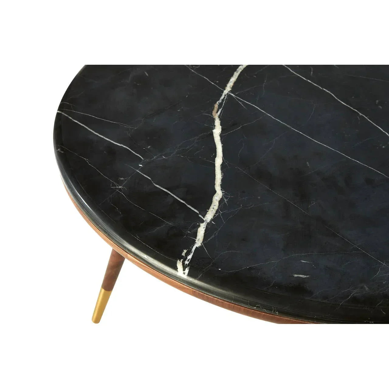 Round black marble coffee table with white veining and angled wood legs with gold tips
