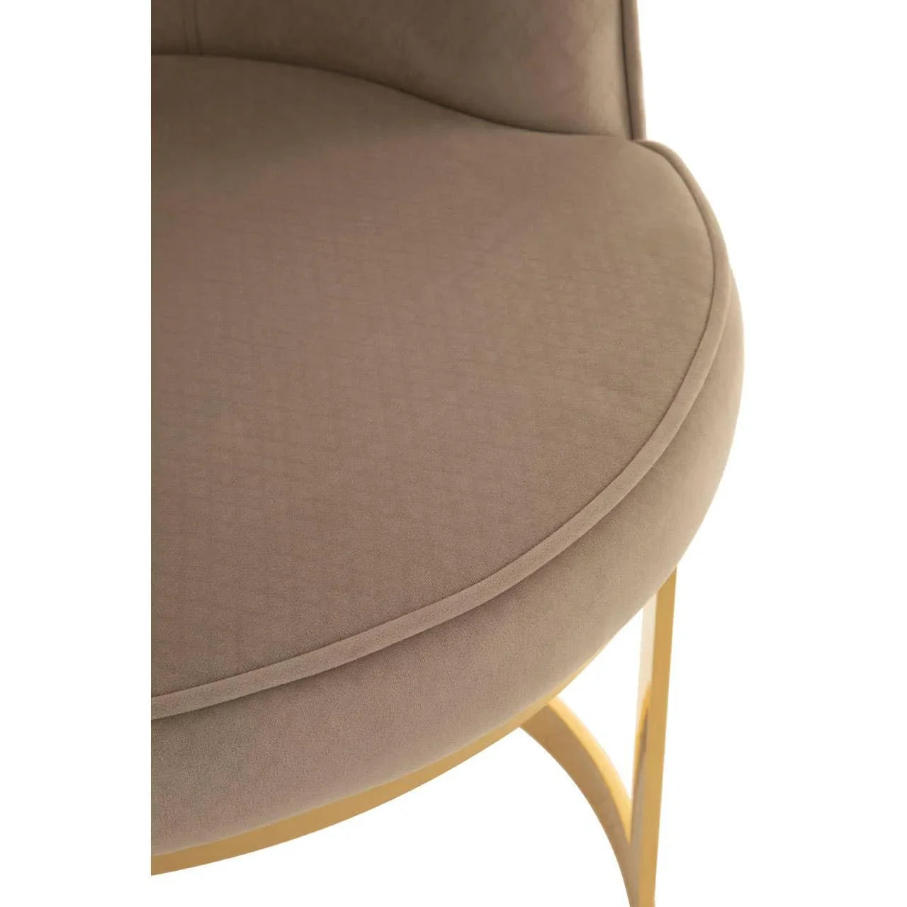 Taupe velvet dining chair seat with gold metal legs, close up view of upholstery and frame