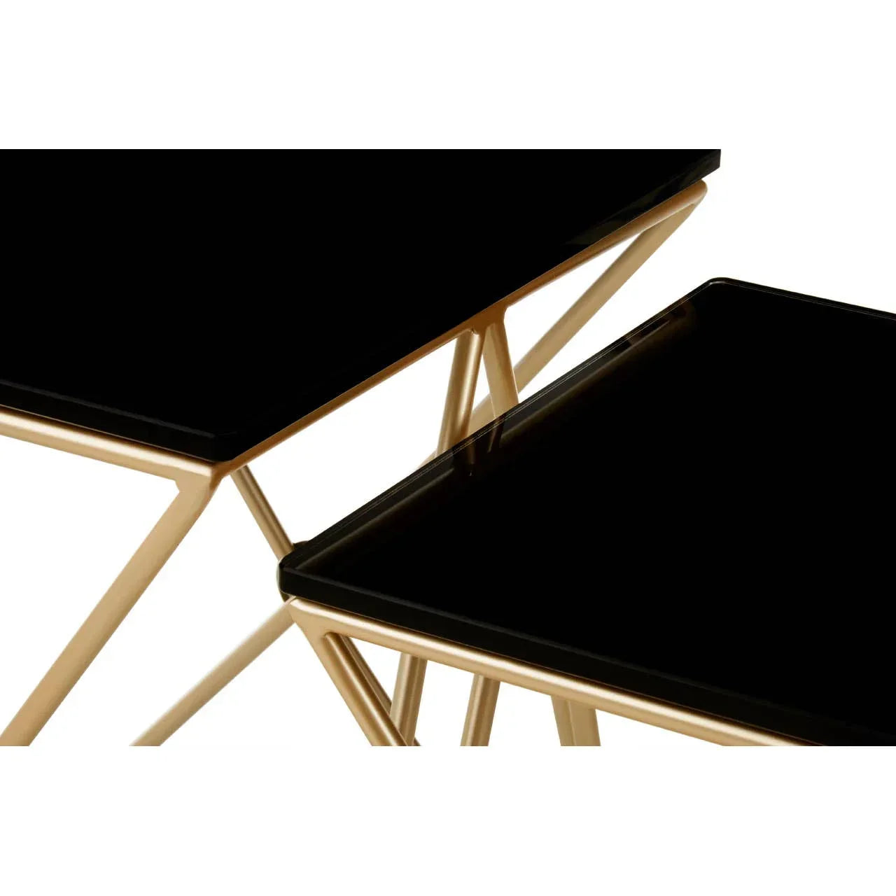 Black glass nesting tables with gold geometric metal frames, close-up of tabletop corners