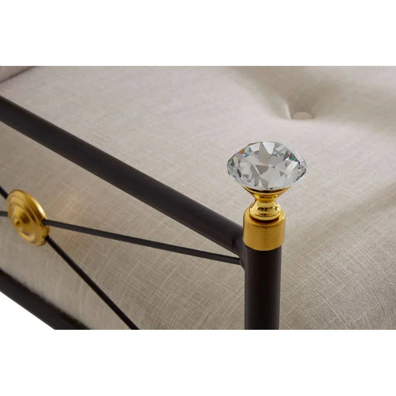 Metal bed frame corner with crystal finial, gold accents and cream upholstered panel