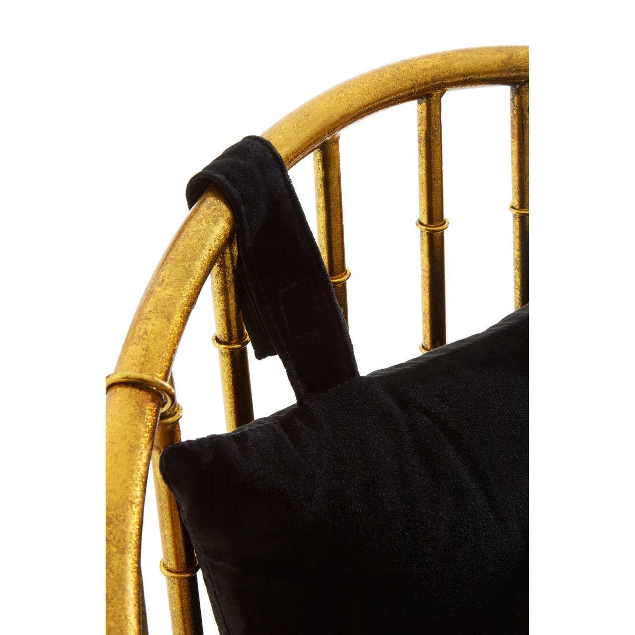 Gold metal armchair frame with black velvet cushion and strap detail