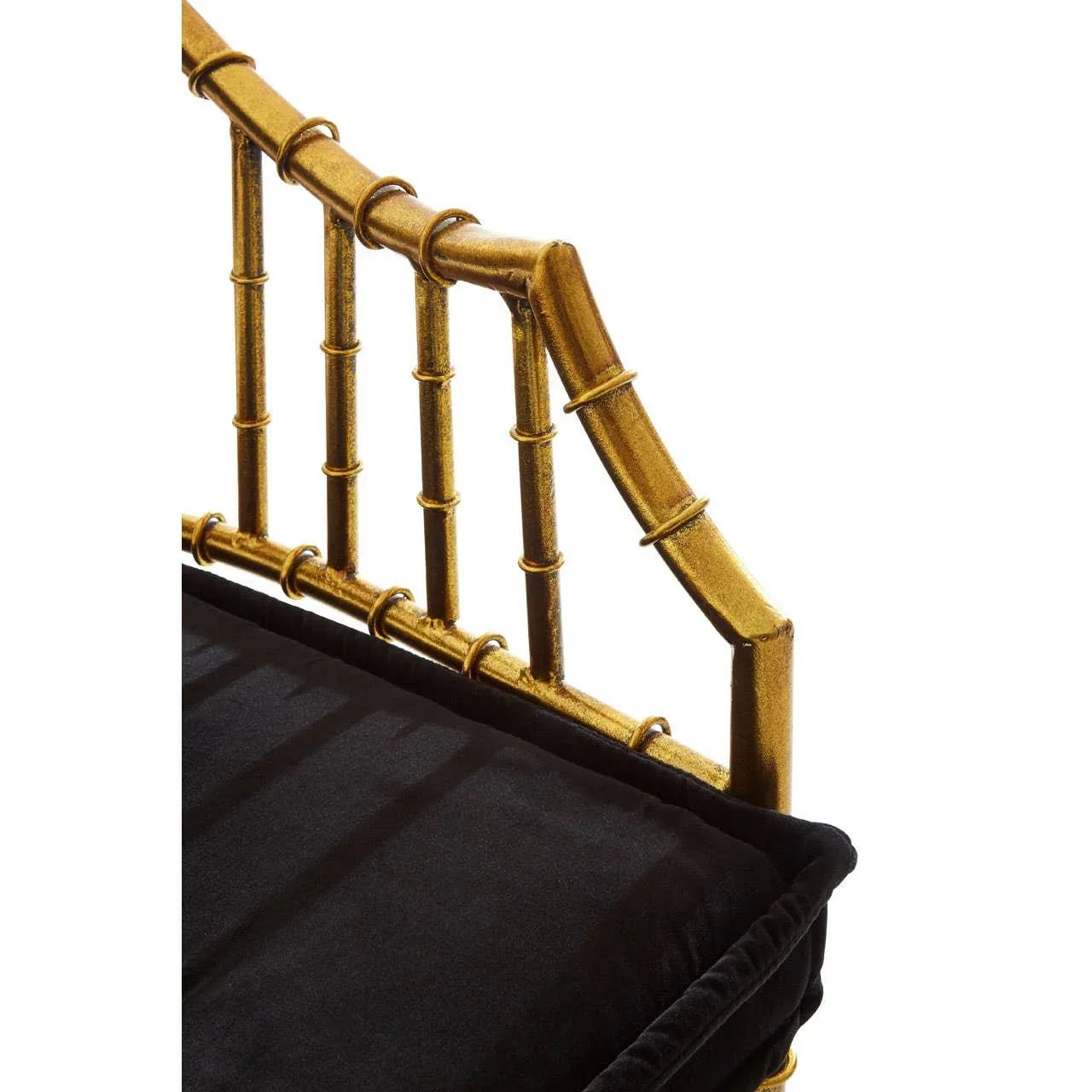Gold metal chair armrest detail with black seat cushion, bamboo-style frame