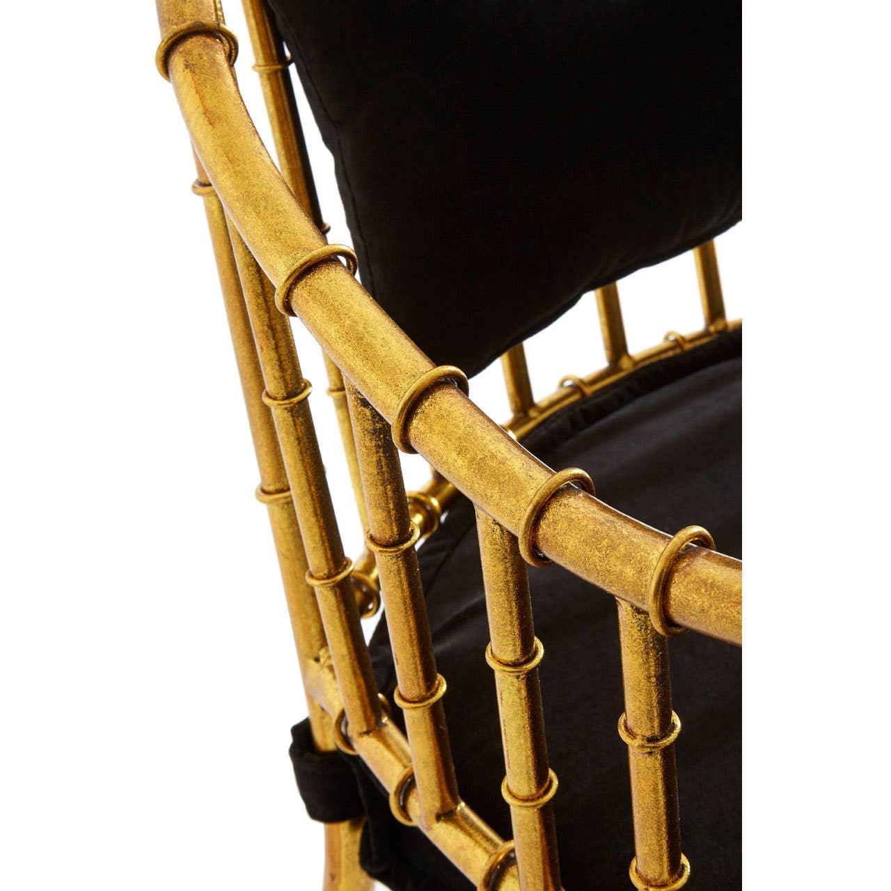 Gold bamboo-style chair frame with black seat and back cushion, close-up detail