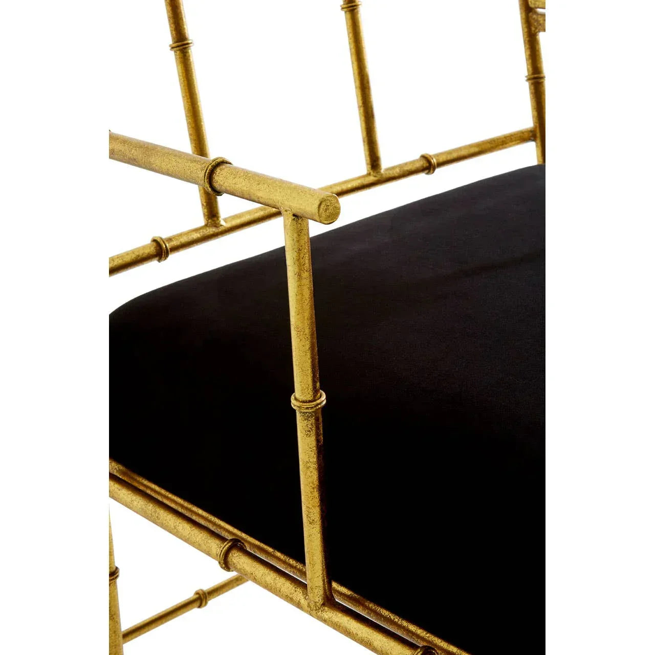 Gold metal chair arm detail with black upholstered seat