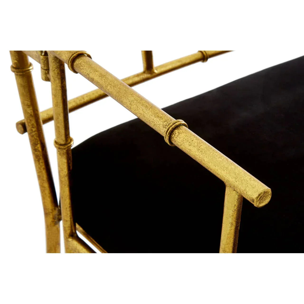 Gold metal chair armrest detail with black upholstered seat