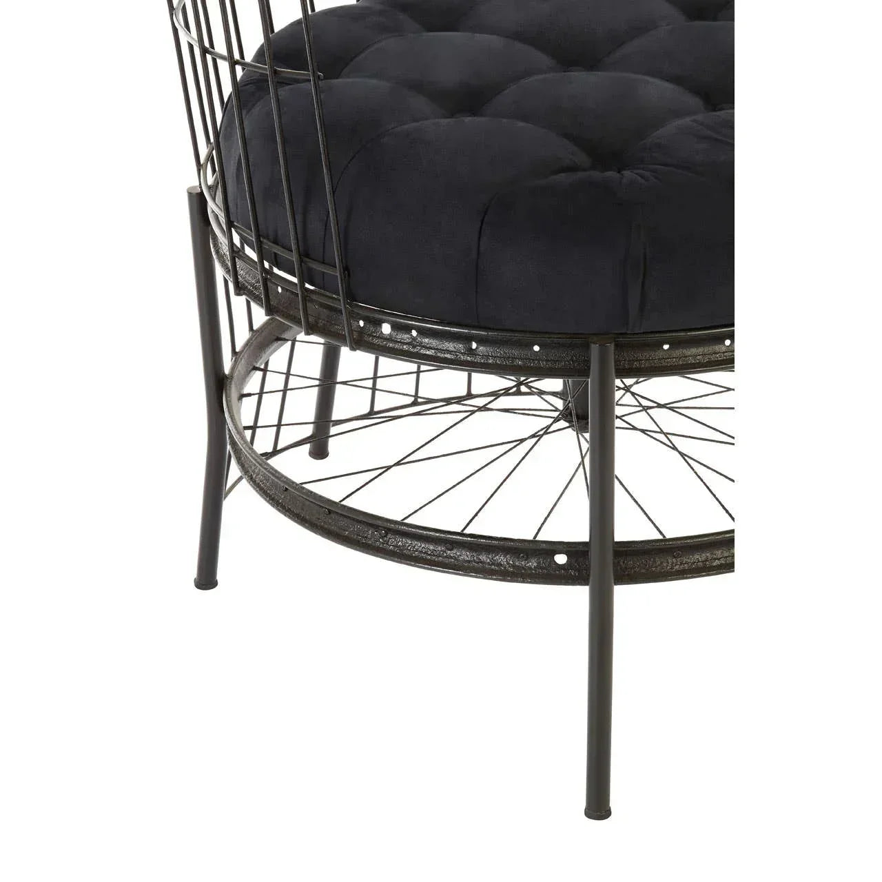 Black velvet cushioned accent chair with metal wire frame and round base, close view