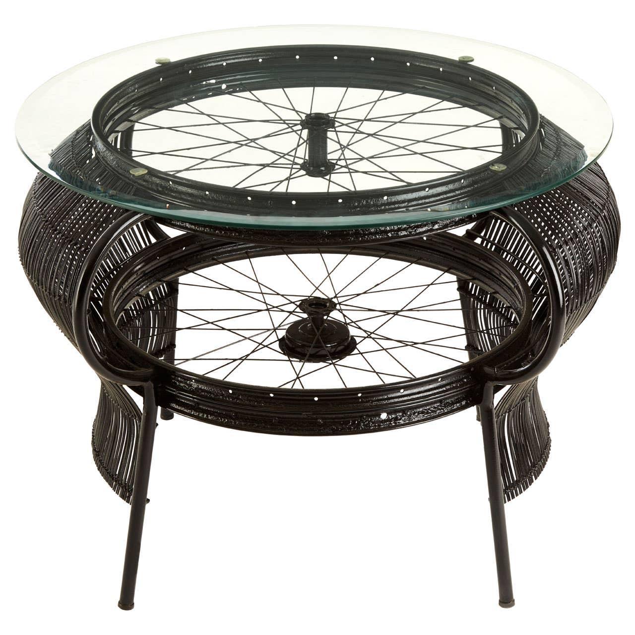 Round glass top coffee table with black metal frame and bicycle wheel detail