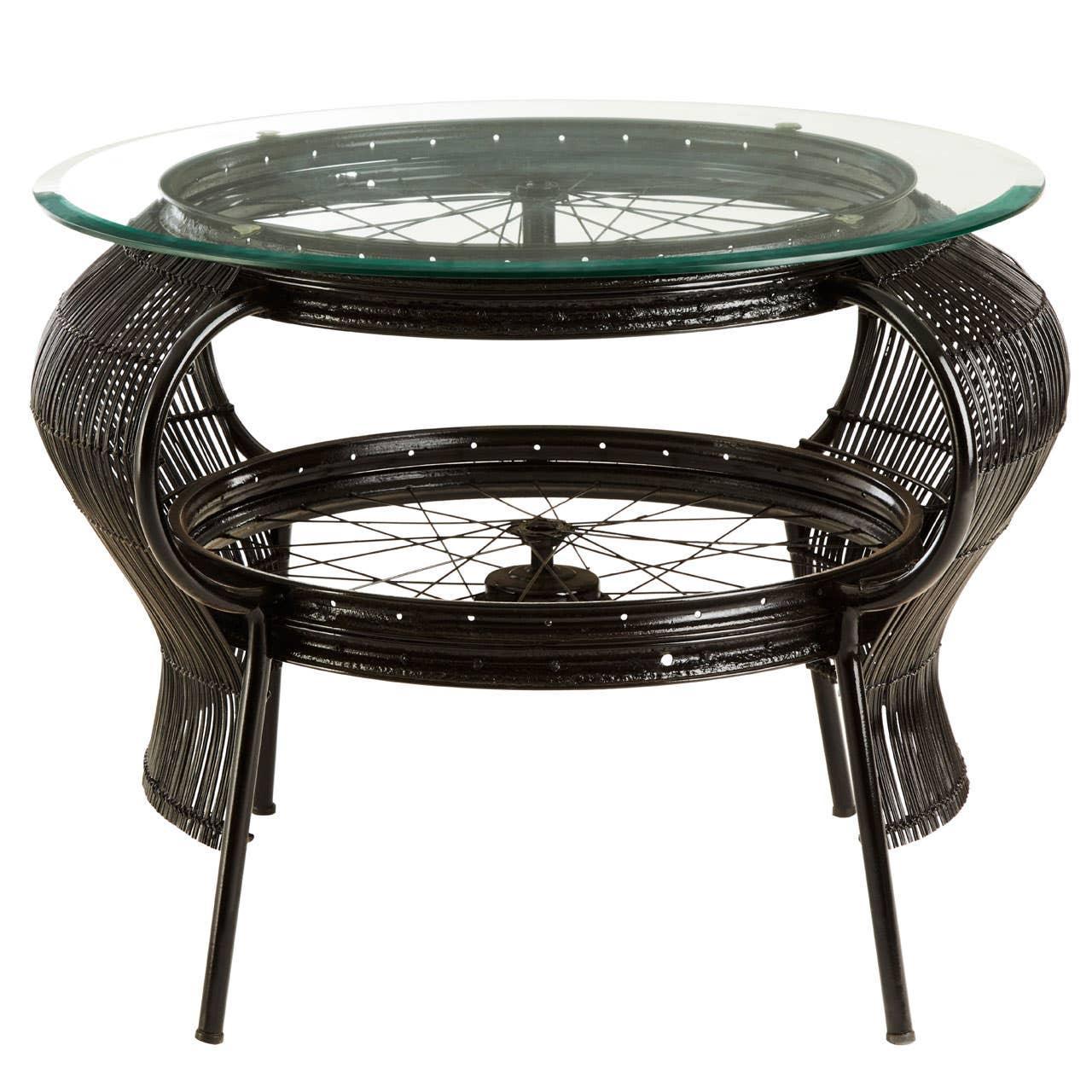 Round black rattan coffee table with glass top and metal spokes, contemporary design