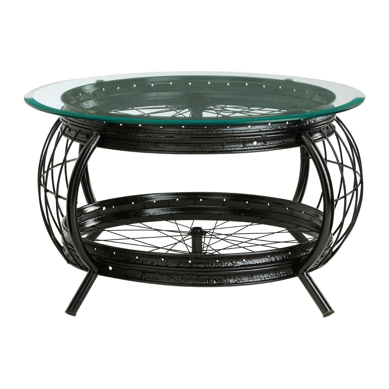 Round industrial coffee table with black metal frame and glass top featuring wheel accents