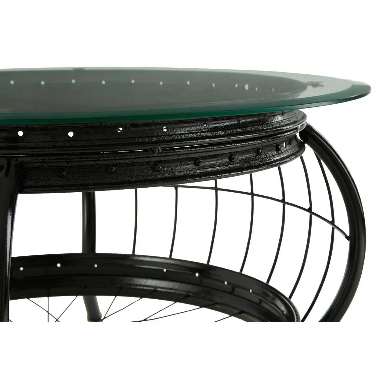 Round metal coffee table with glass top and black wire frame detail, side angle view