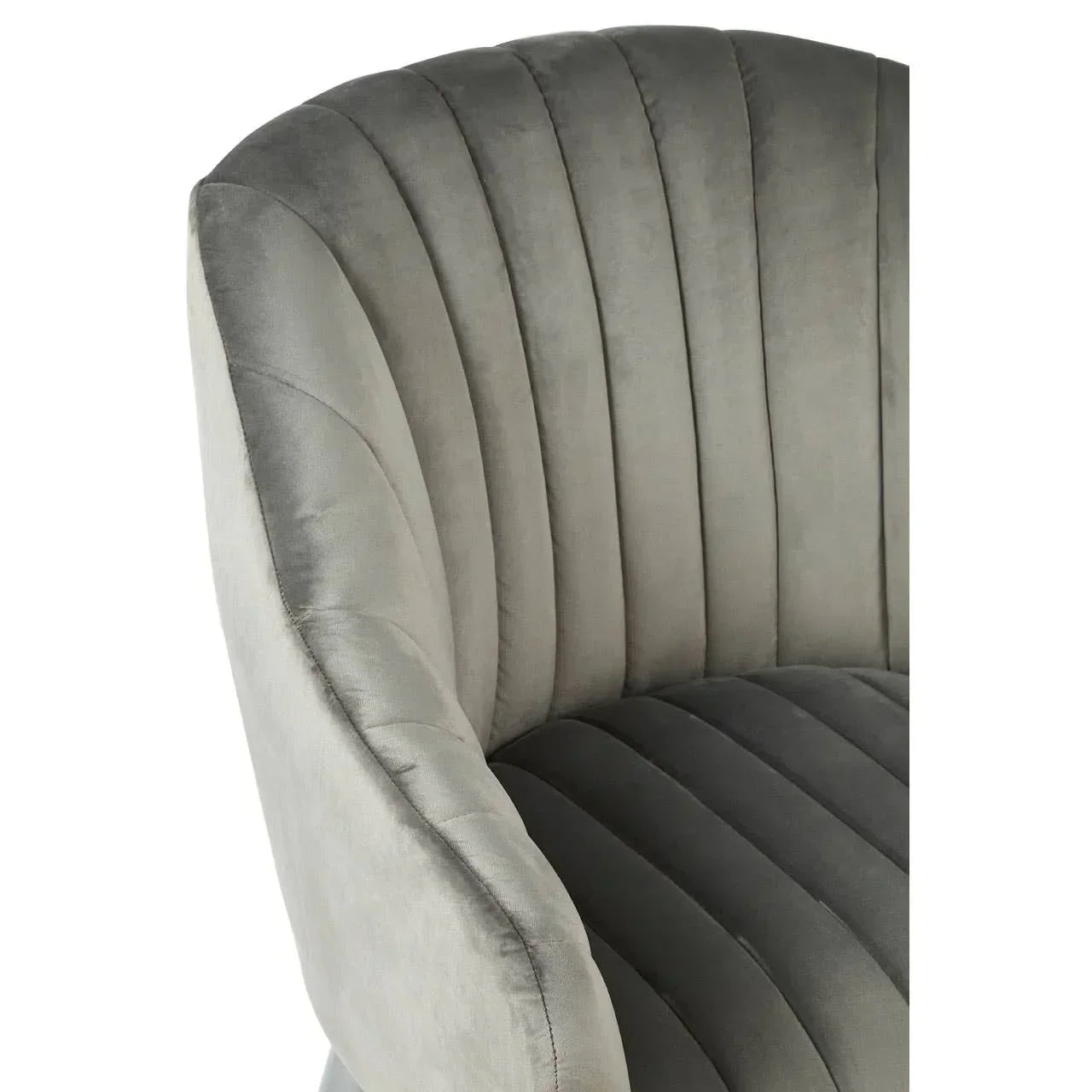Closeup of grey velvet armchair with vertical channel tufted upholstery