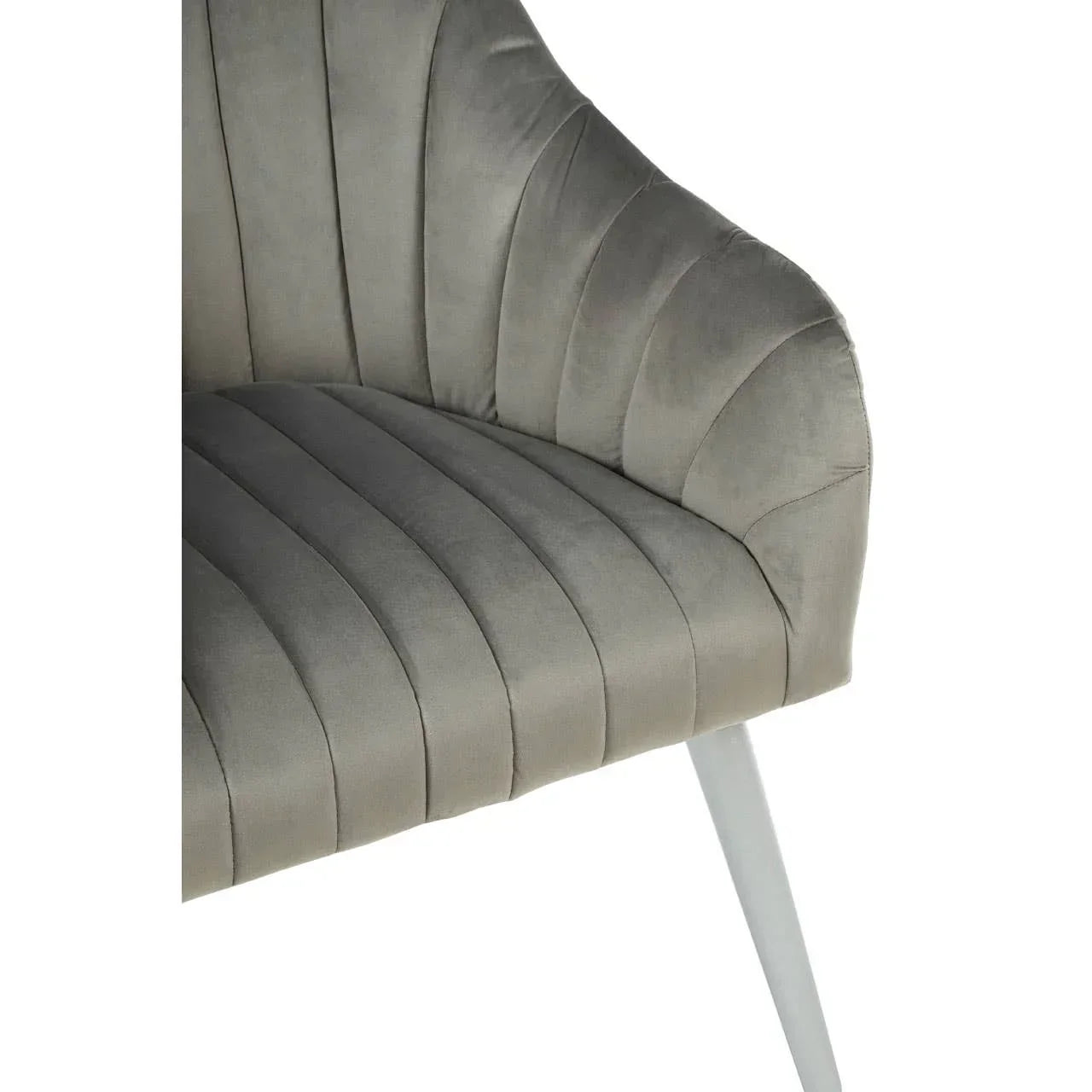 Close view of grey velvet dining chair with vertical stitching and angled white leg