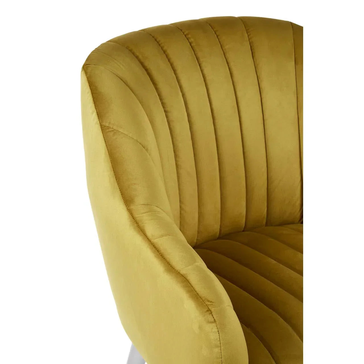 Mustard velvet armchair with curved backrest and vertical tufted detail, close-up view