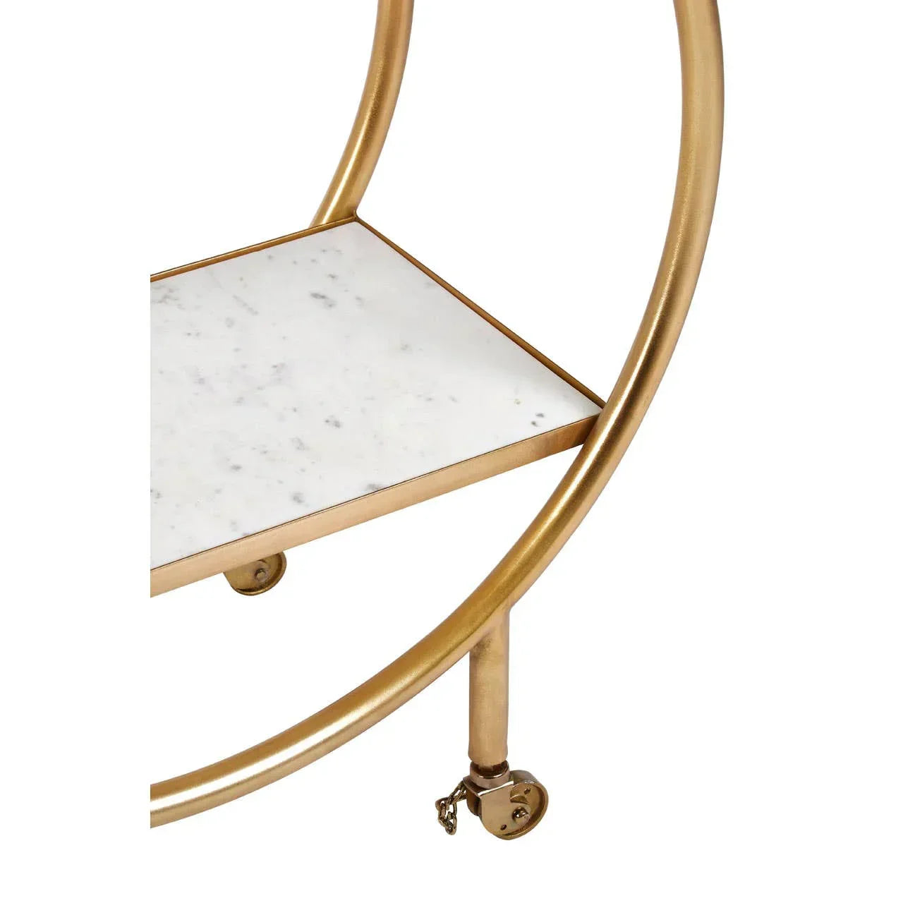 Gold metal drinks trolley with white marble shelf and caster wheels close up