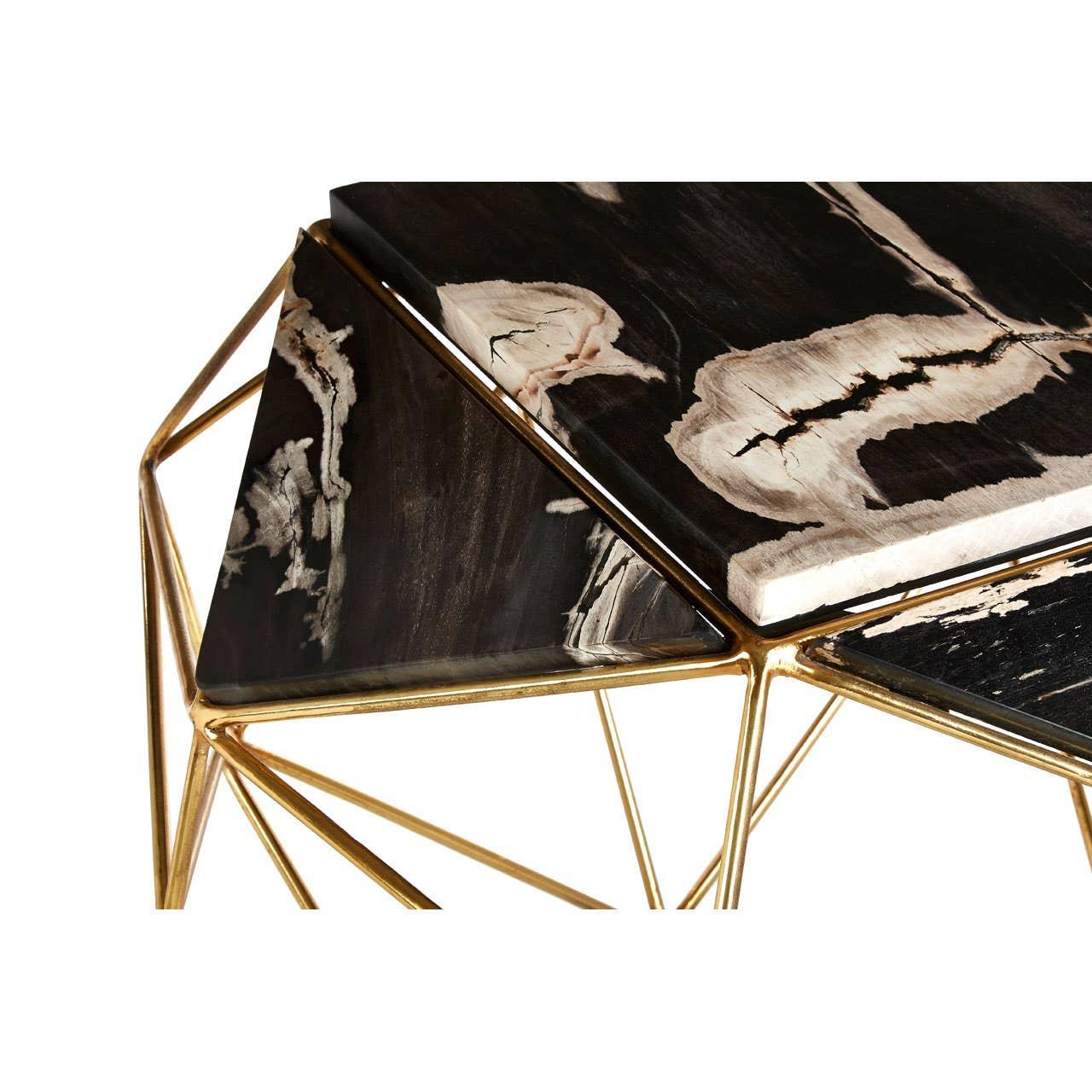 Modern coffee table with black marble top and geometric gold metal frame, close-up angle