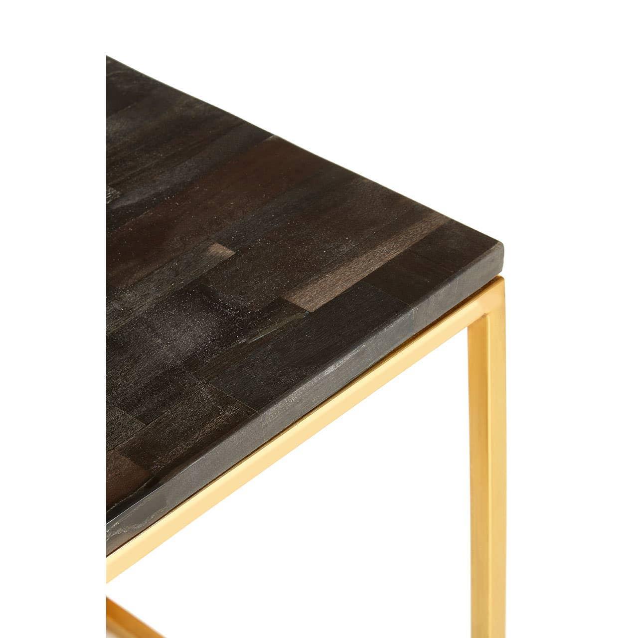 Dark wood tabletop with gold metal legs, close-up corner detail of dining table
