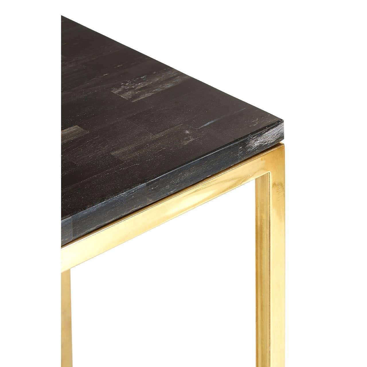 Black wood table top with gold metal frame, close-up of corner and leg detail