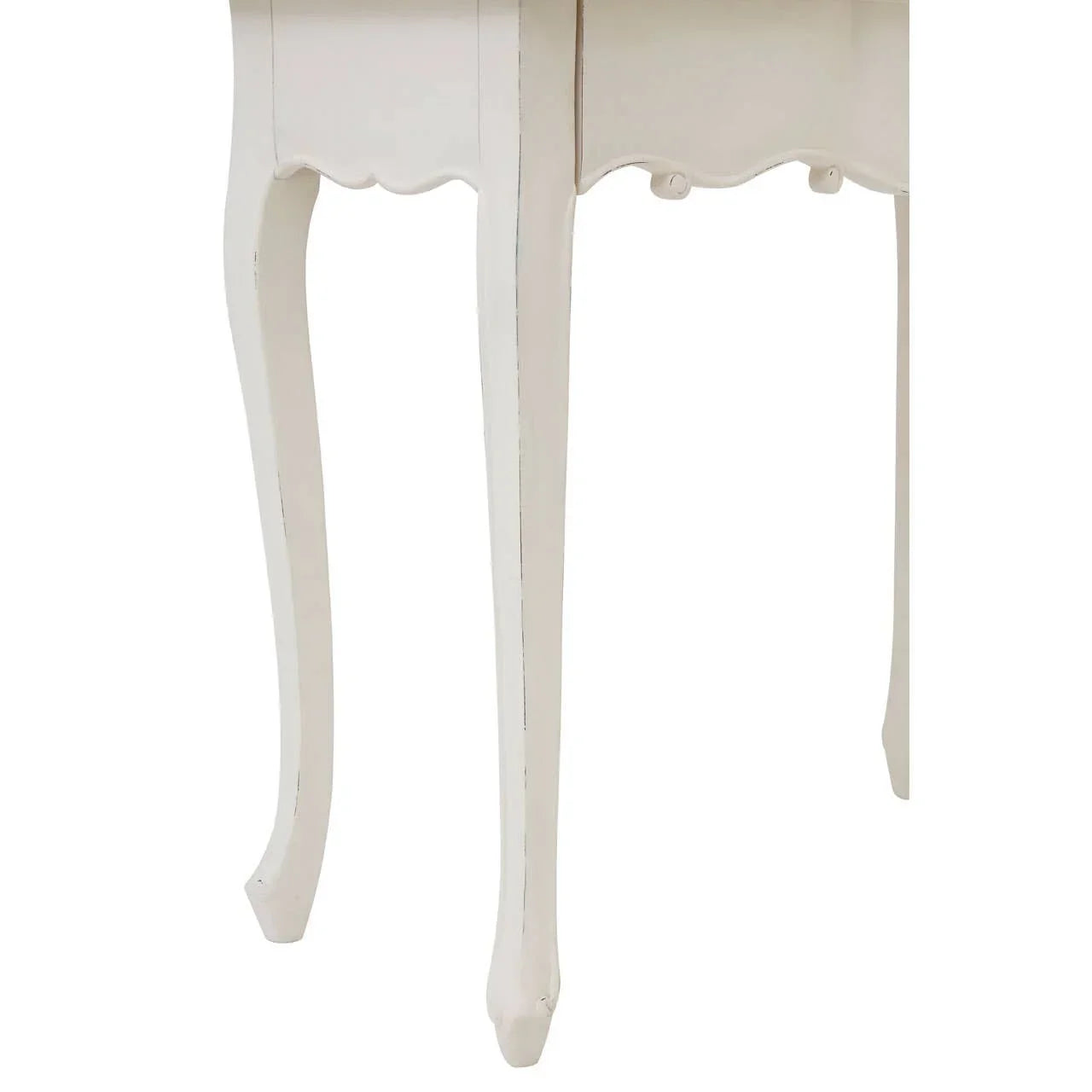 Close view of white wooden table legs with curved design and scalloped trim