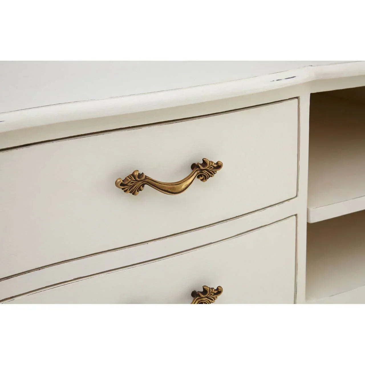 Cream wooden drawer unit with ornate brass handle and open shelf detail