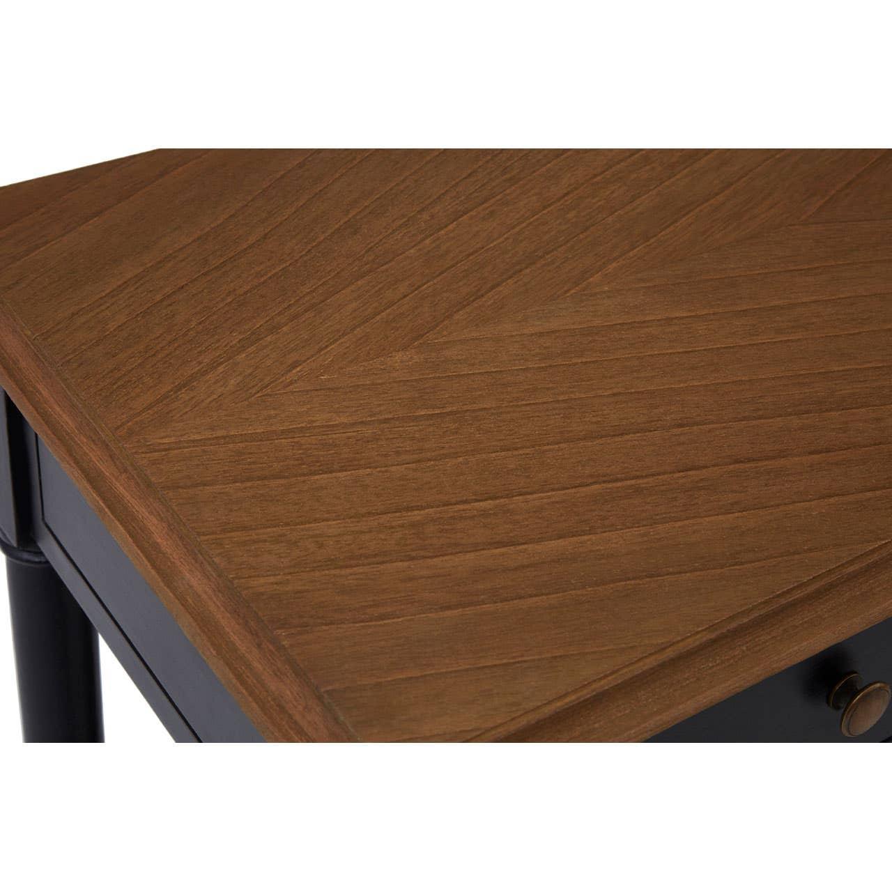 Close view of wooden table top with chevron pattern and dark painted drawer