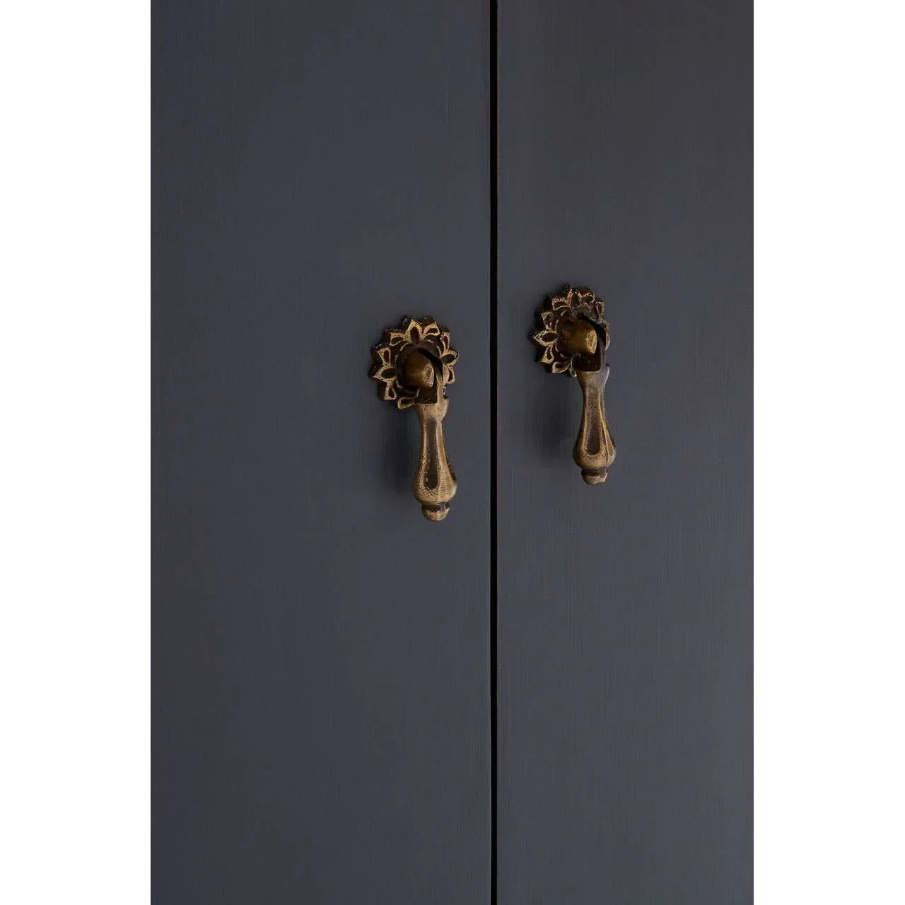 Close-up of dark wardrobe doors with antique brass handles