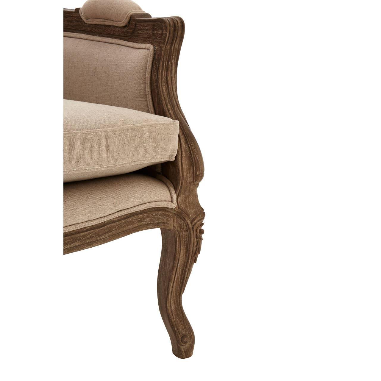 Close up of carved wooden sofa leg and beige linen upholstery with seat cushion