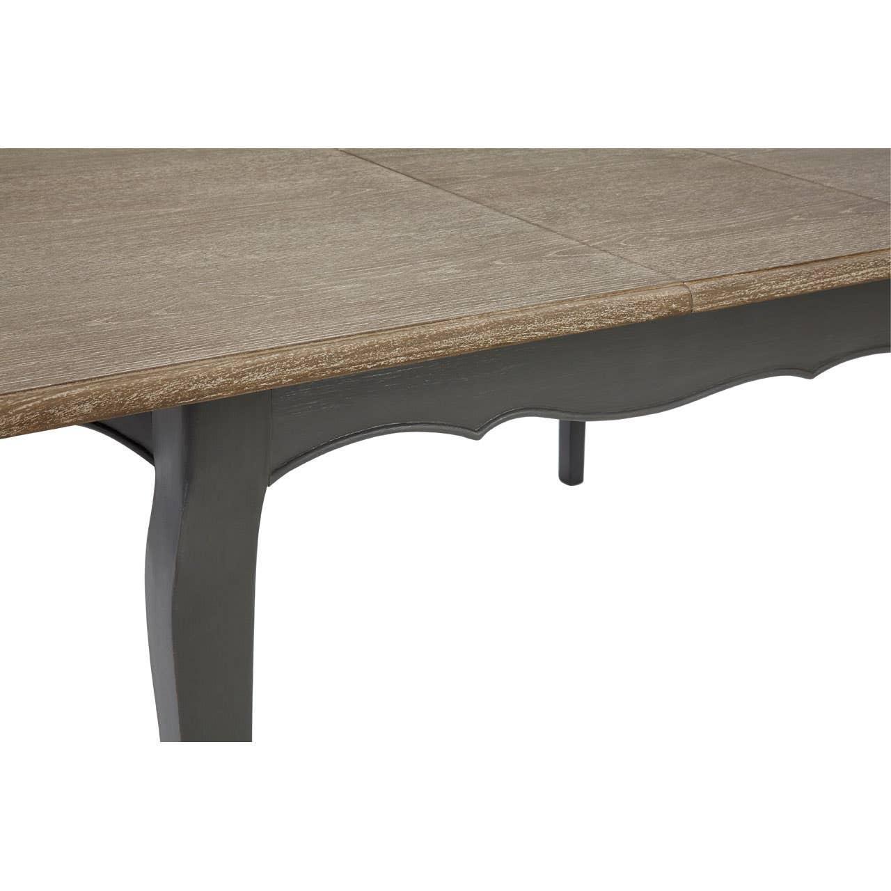 Closeup of wooden dining table with oak finish top and dark curved legs