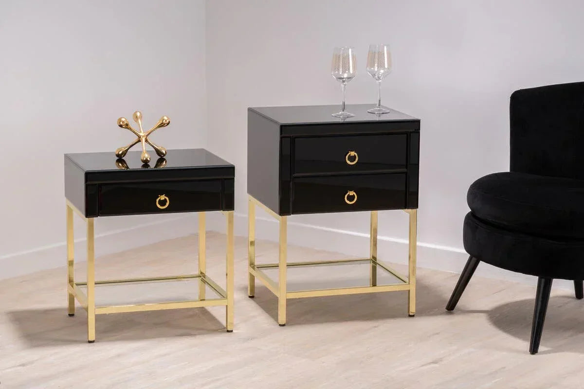 Black gloss bedside tables with gold metal legs and drawers, styled in a modern room