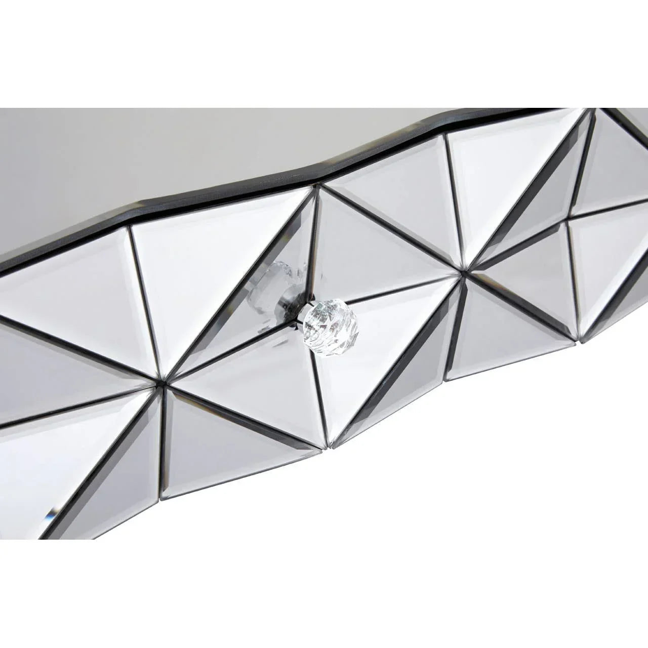 Closeup of mirrored geometric drawer front with glass knob on bedroom furniture
