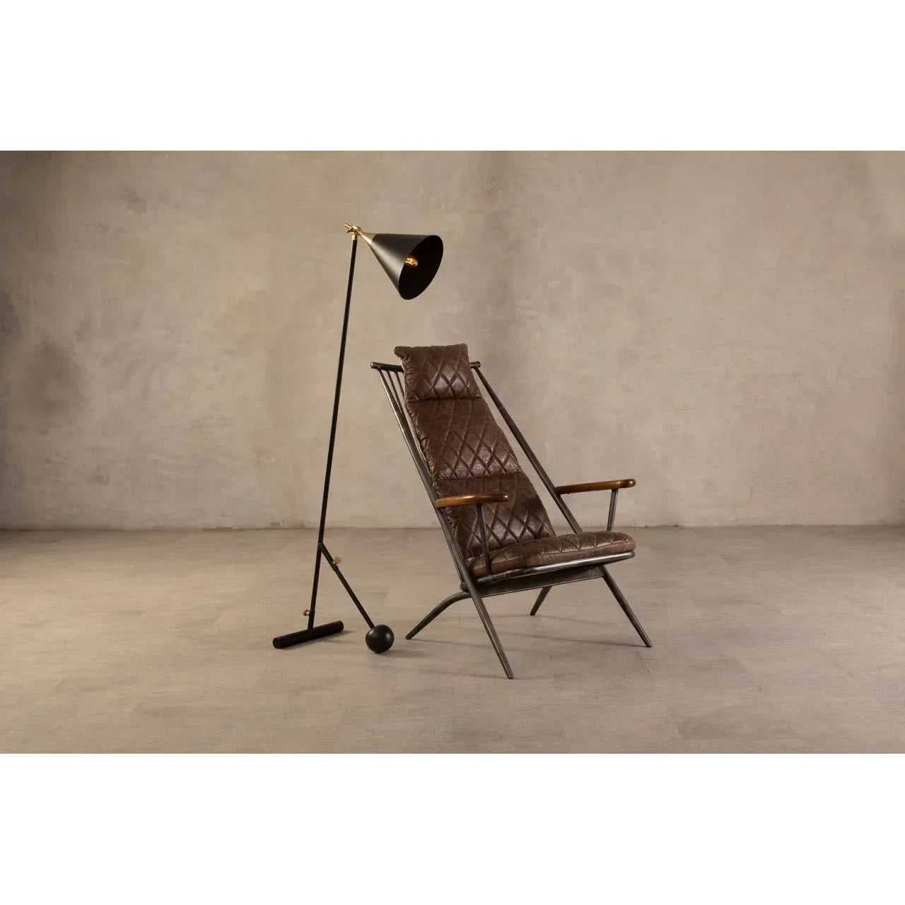 Brown leather armchair with diamond stitching beside black metal floor lamp
