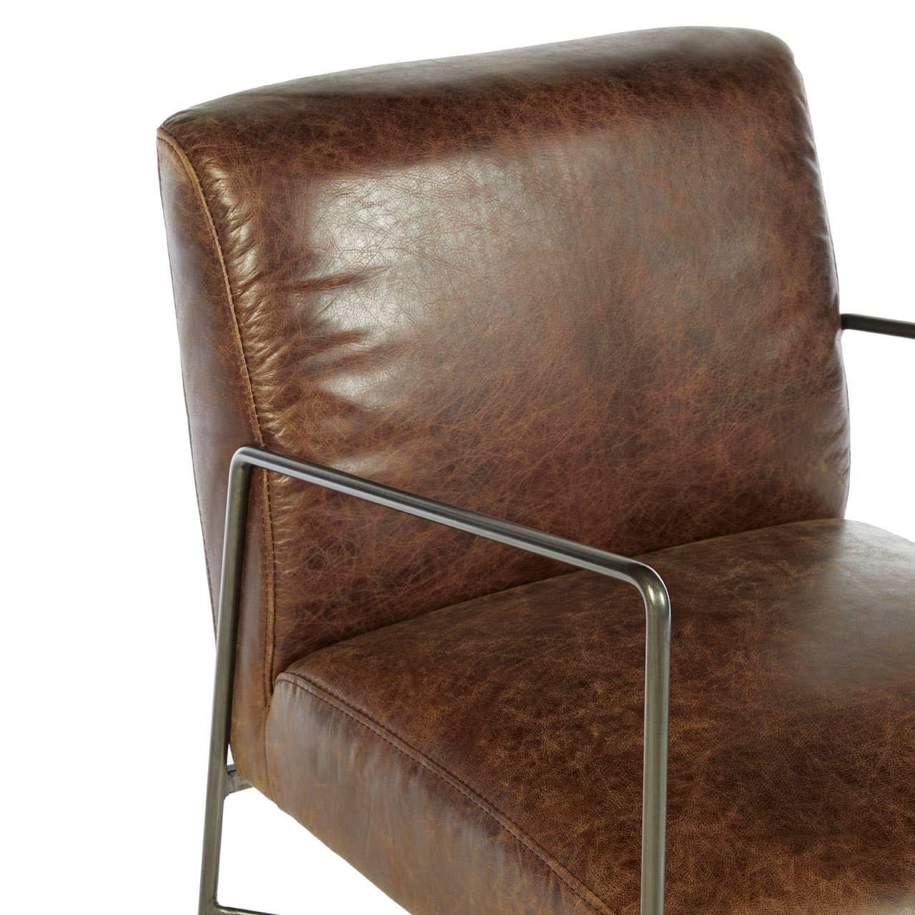 Brown leather armchair with metal frame, close-up of seat and backrest