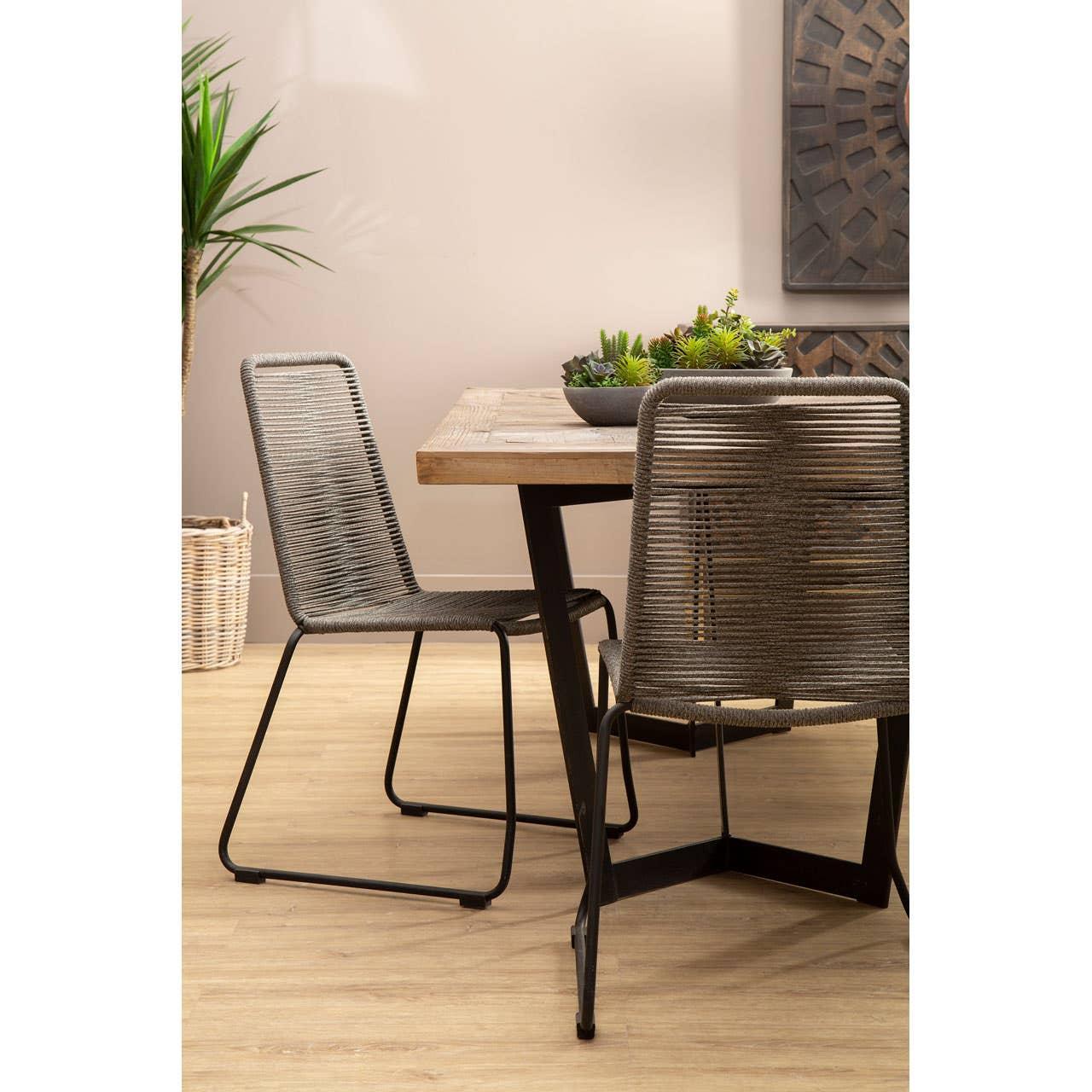 Wood dining table with rope dining chairs and black metal legs, indoor setting