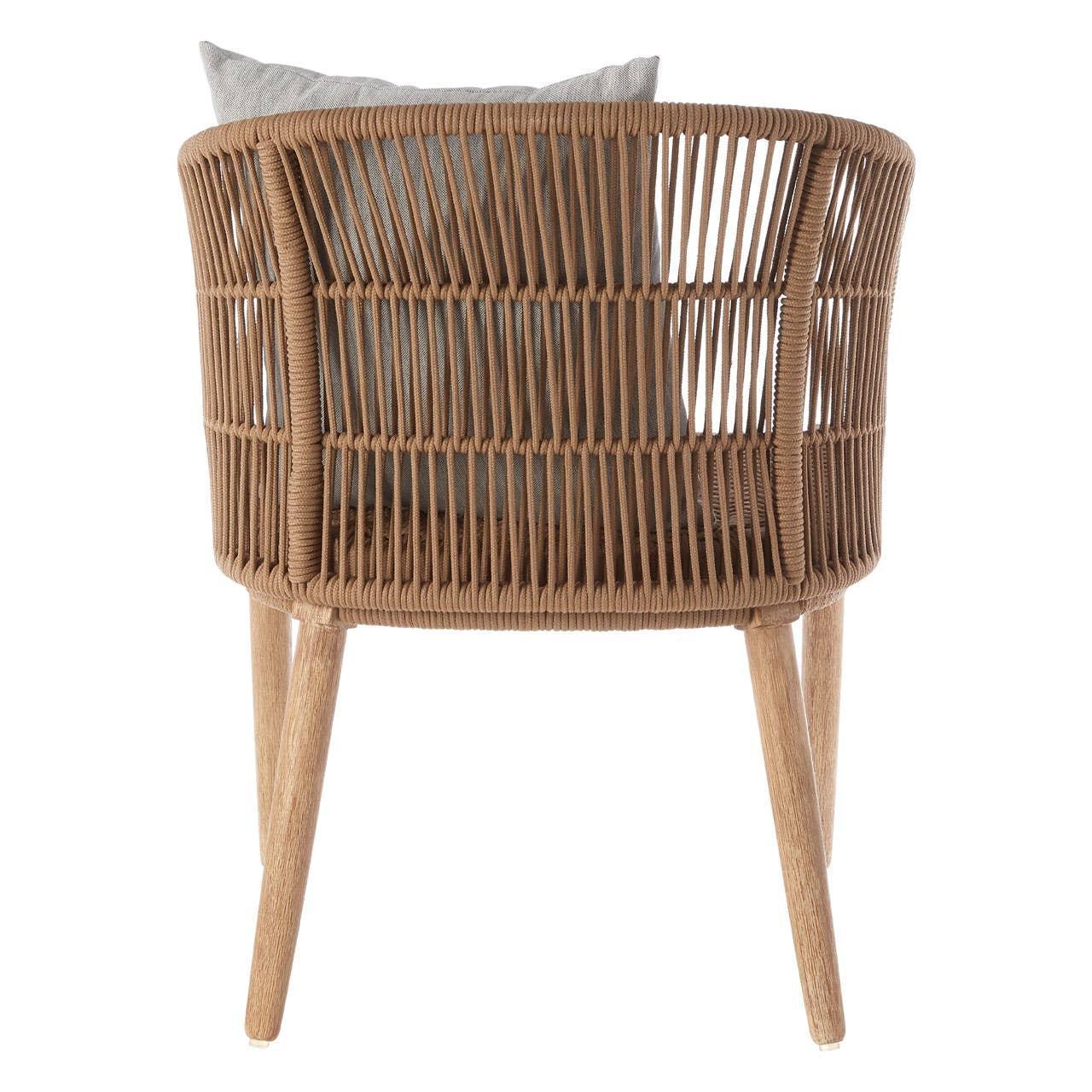 Back view of woven rattan armchair with wooden legs and grey cushion