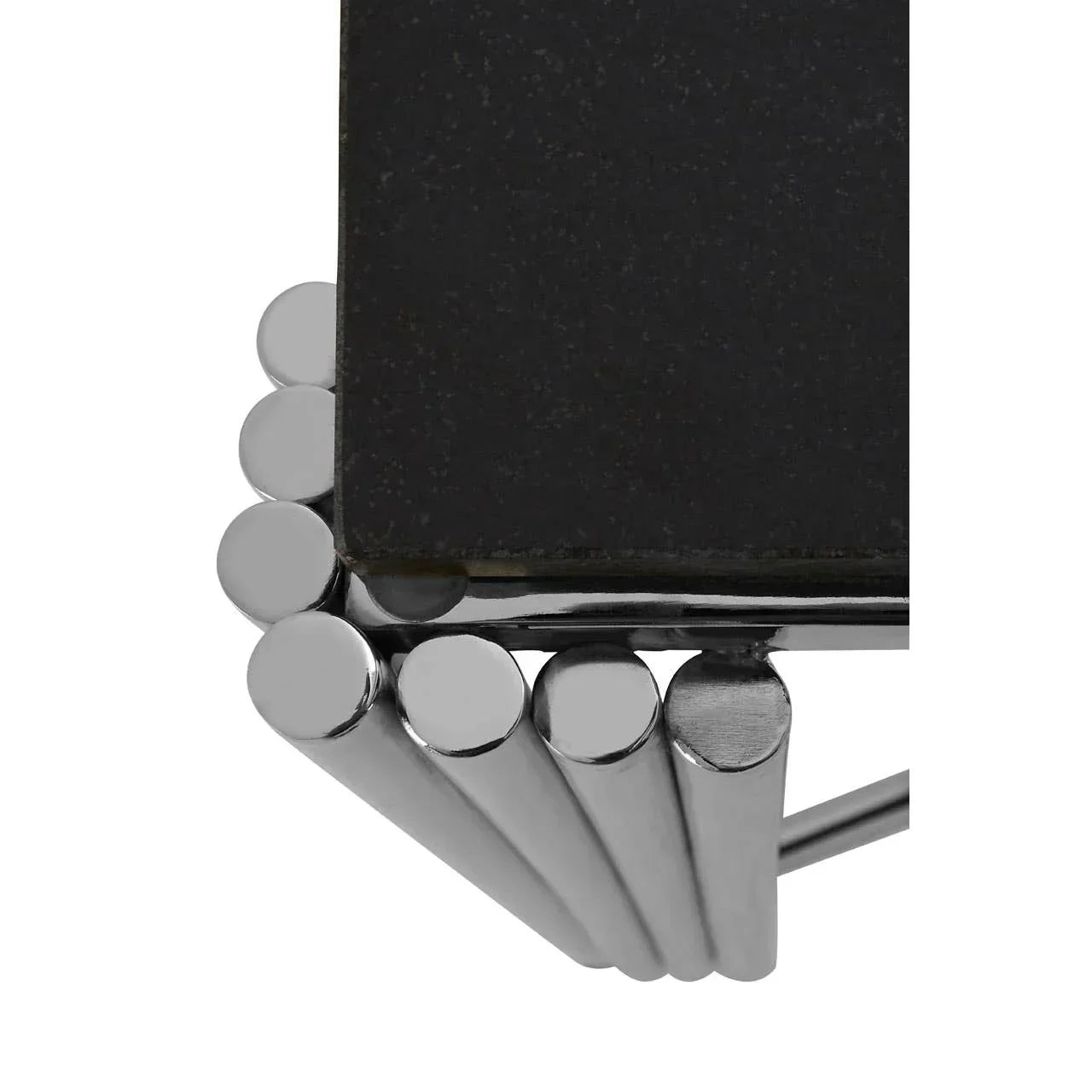 Corner detail of black stone coffee table with chrome cylindrical legs