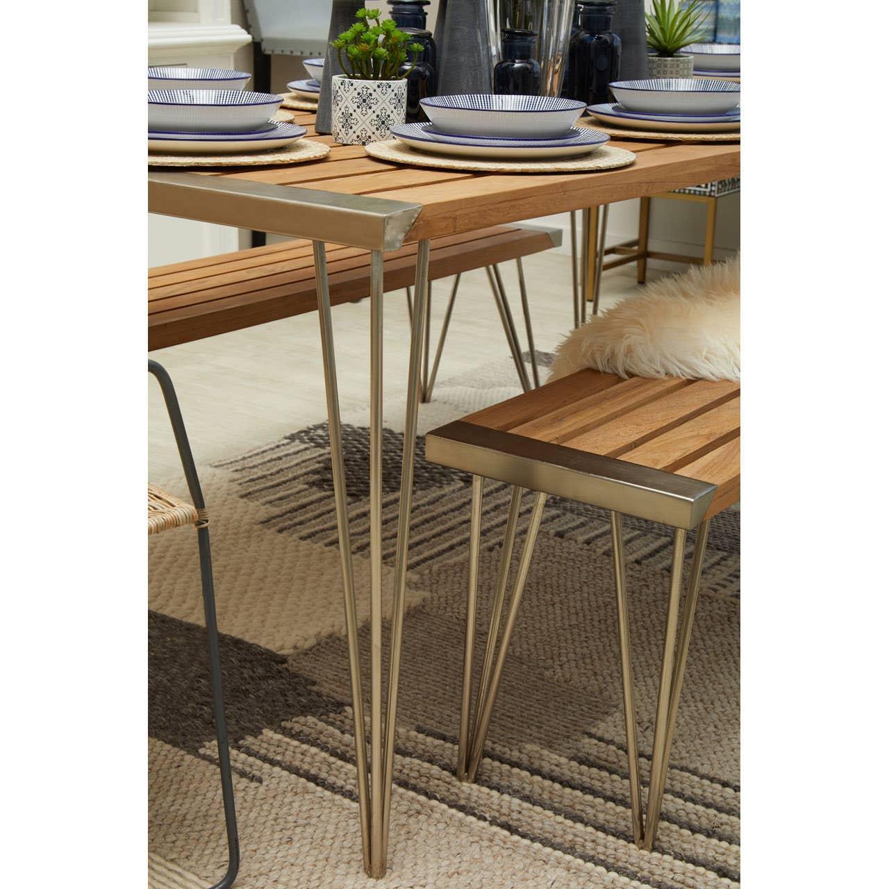 Wooden dining table and bench with metal legs set for four on patterned rug