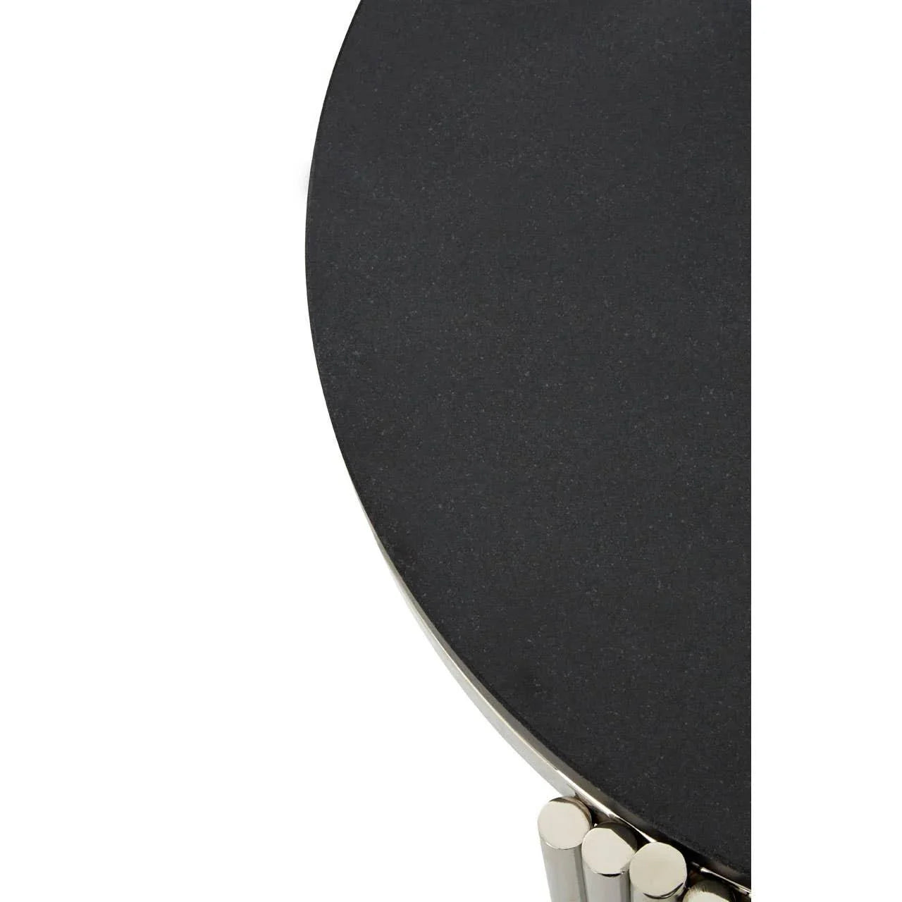 Black round side table with stone top and chrome tube legs, close-up view