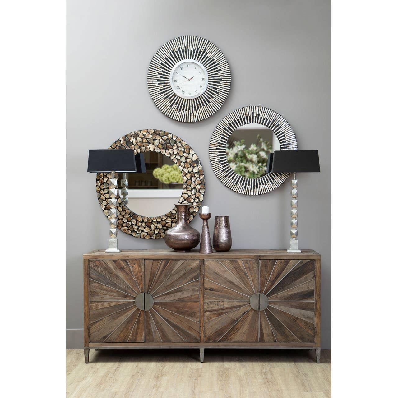 Wood sideboard with sunburst pattern, decorative mirrors, vases, and two silver lamps