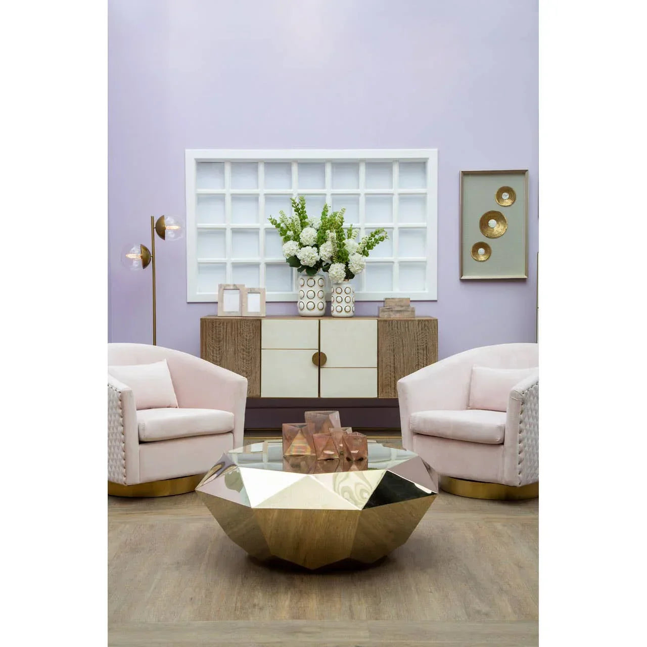Geometric gold coffee table with blush velvet armchairs in a modern living room setting