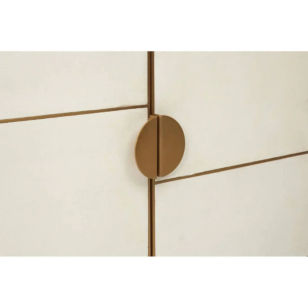 Close-up of gold metal cabinet handle on cream panelled furniture door