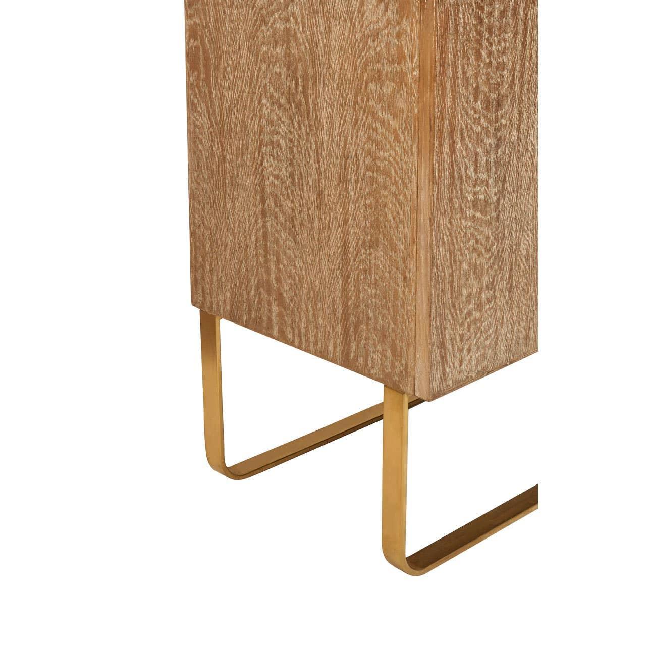 Oak wood cabinet corner with gold metal legs, close-up on base and wood grain detail