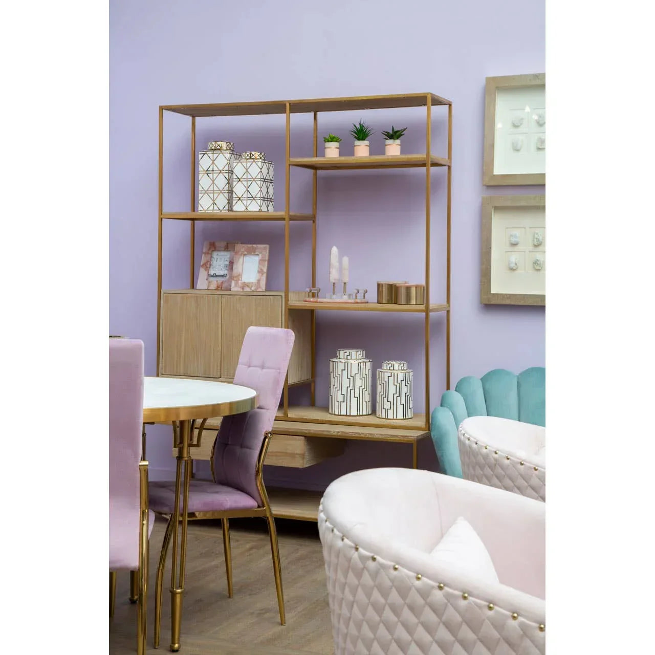 Modern shelving unit with gold frame, storage jars, plants and pastel dining chairs