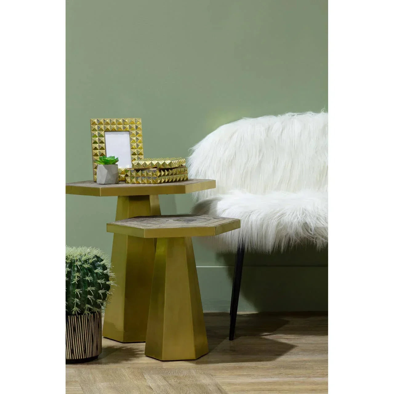 Gold hexagonal side tables with geometric decor beside white faux fur accent chair