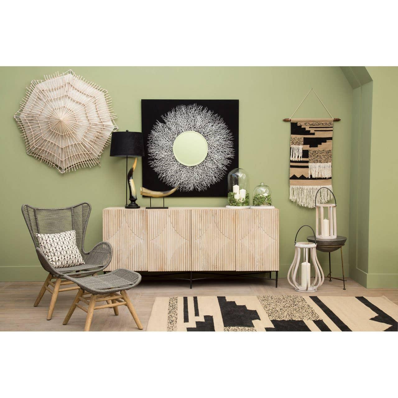 Modern living room with rattan chair, sideboard, wall art and patterned rug