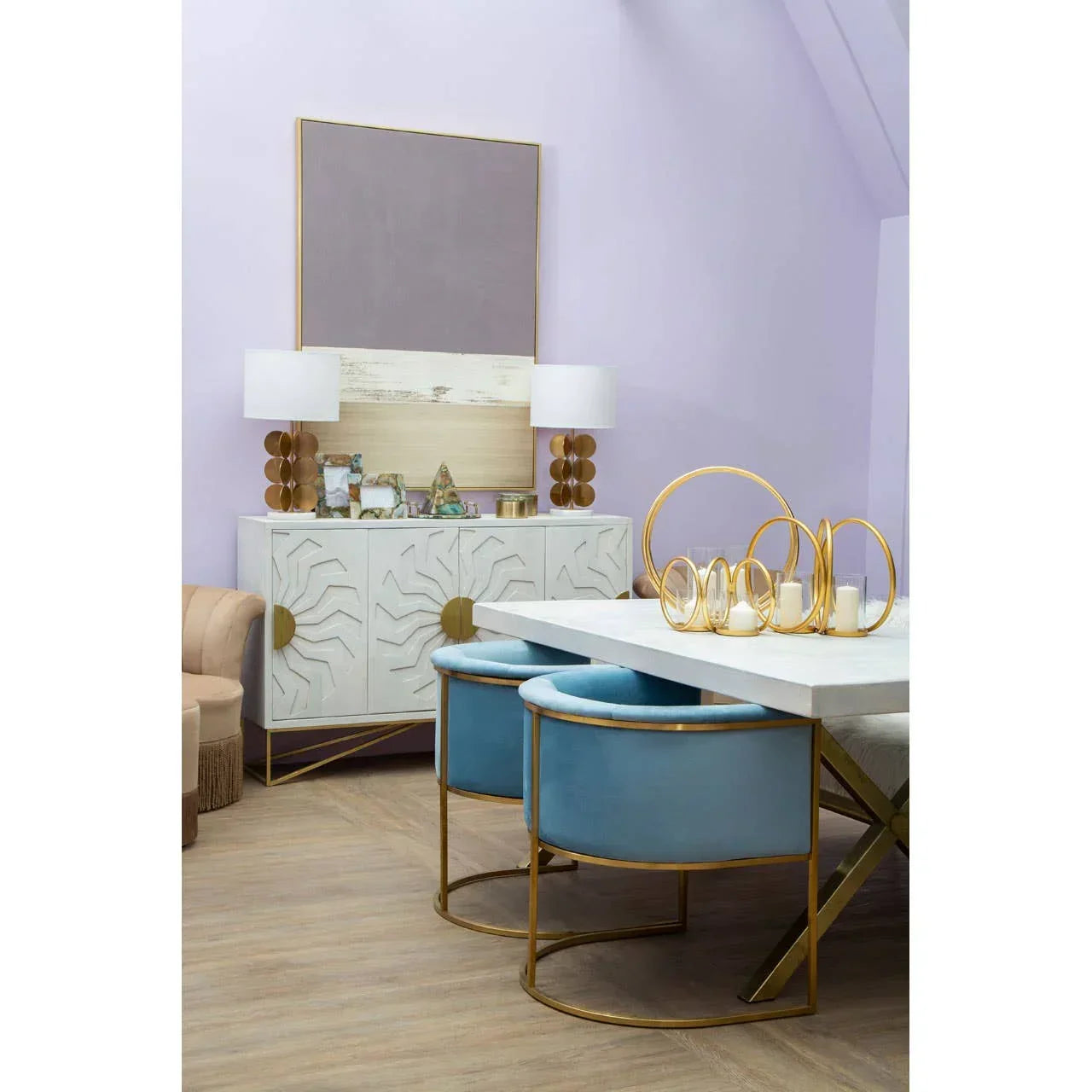 Modern dining room with white dining table, blue velvet chairs and gold accent decor
