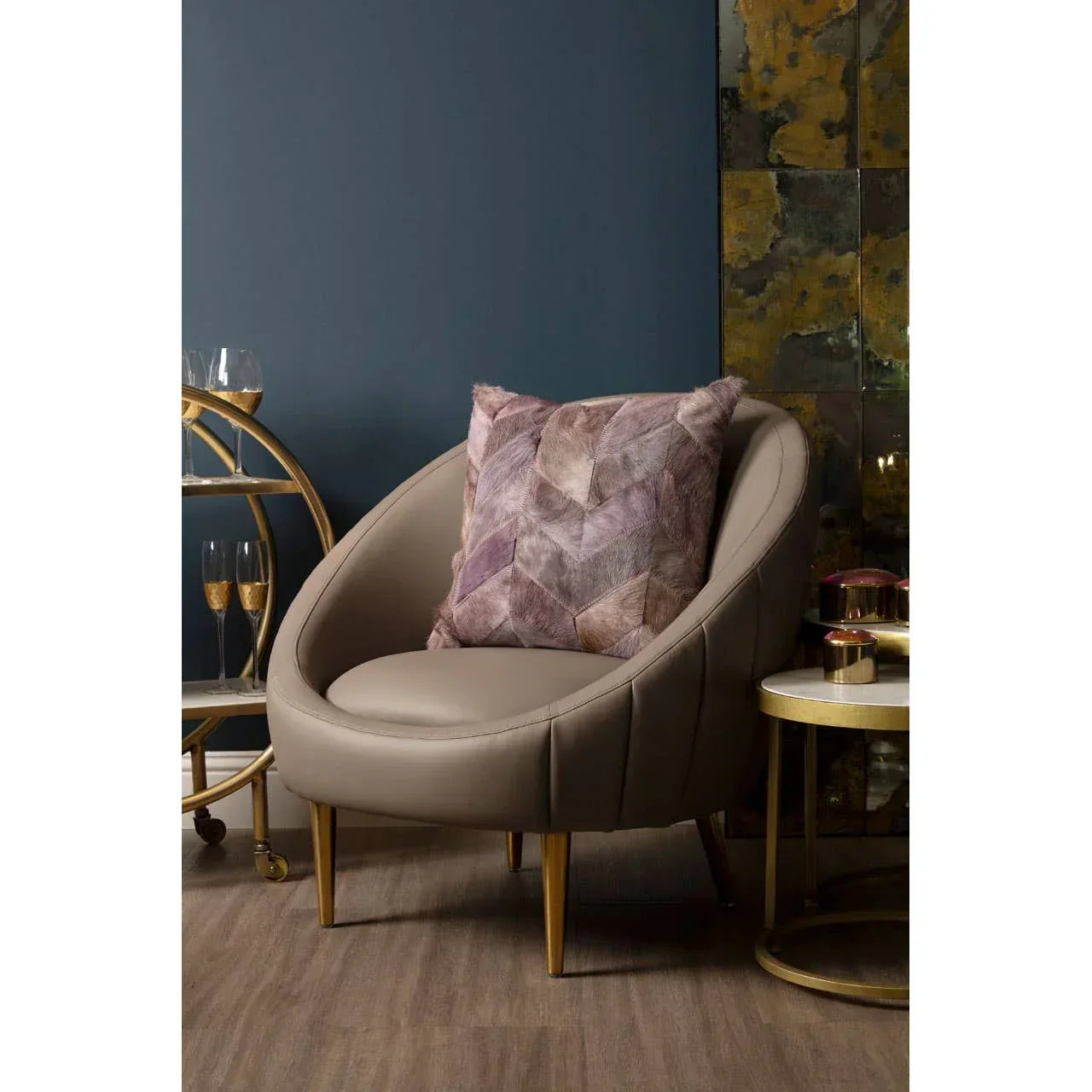 Taupe accent chair with gold legs and mauve geometric cushion in modern living room