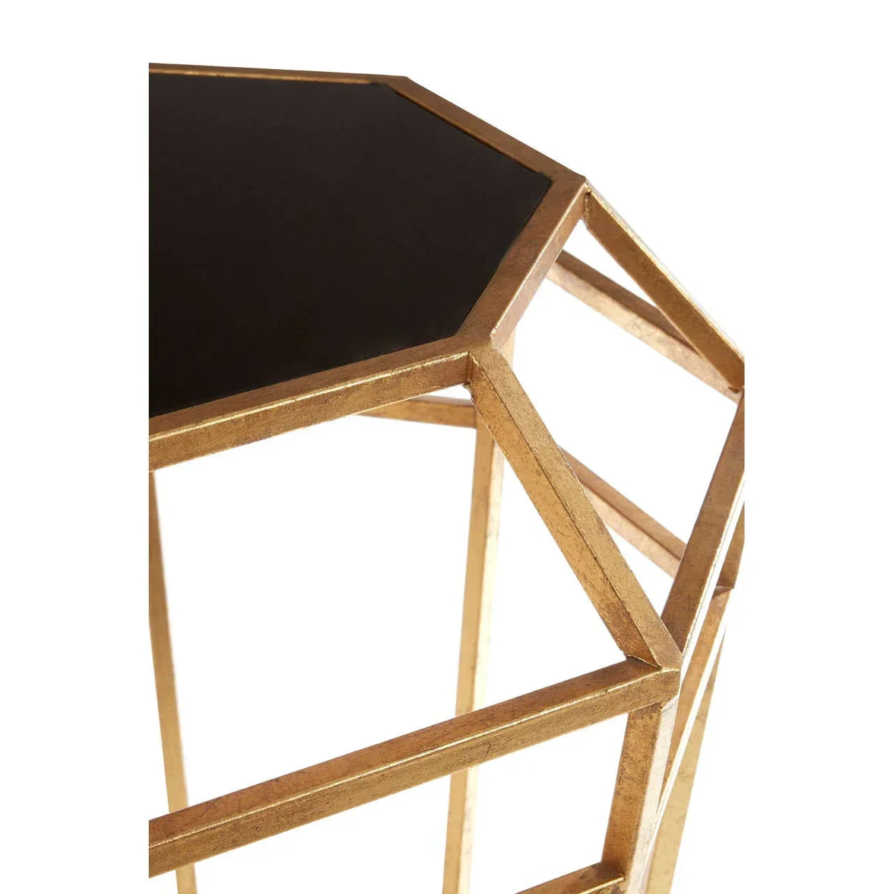 Geometric gold metal side table with black glass top, close-up on frame and surface